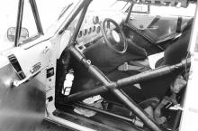 The race car interior mixes '55 components with aluminum wallpaper and a full NASCAR-style rollcage. Note that the controls for the Lincoln's power windows were retained.